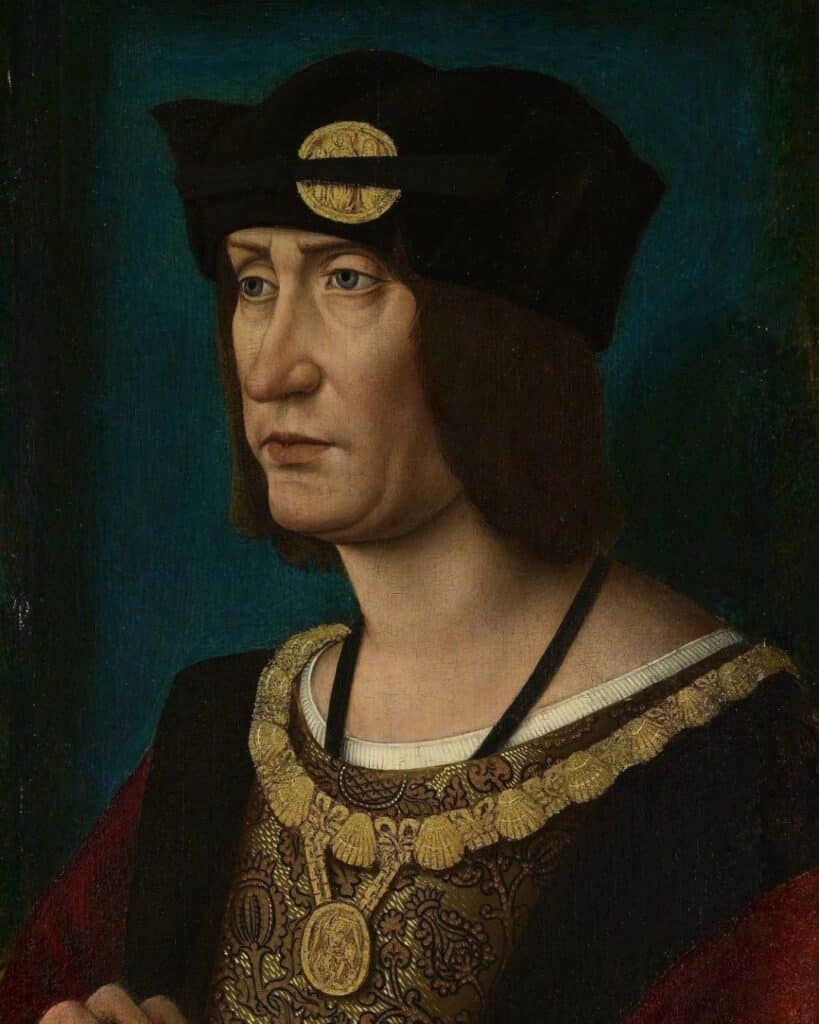 A portrait of a solemn-looking man with shoulder-length brown hair, wearing a dark hat with a golden medallion and an embroidered garment with a gold chain. His expression is serious, and he appears to be a figure of historical significance during Mary Tudor’s lifetime.
