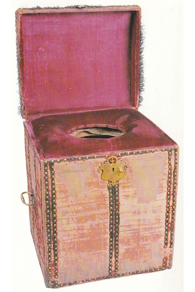A velvet-lined, ornate portable toilet with a keyhole and metal trim, representing the unusual medieval job of the Groom of the Stool—an attendant who helped monarchs with toileting.
