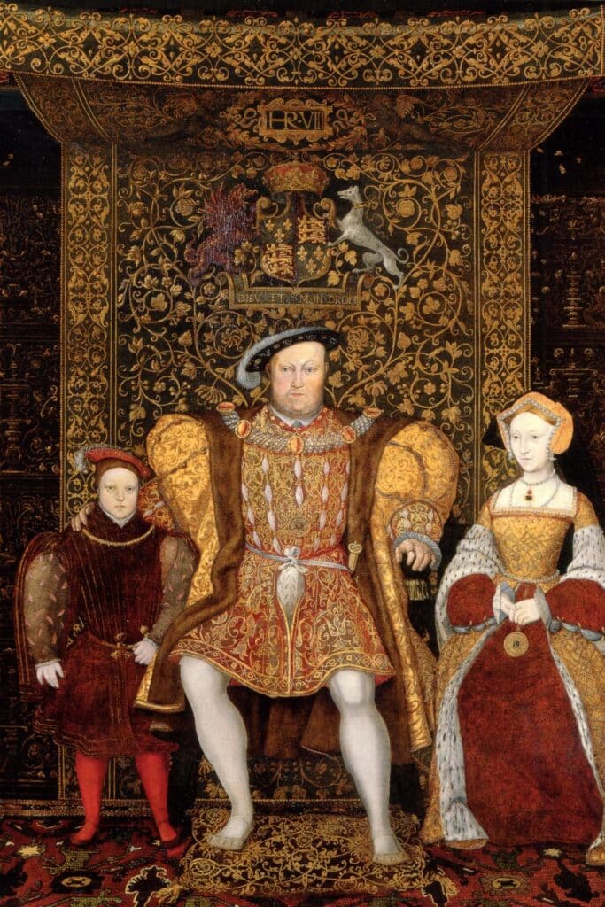 A historic portrait of King Henry VIII seated centrally in regal gold attire, flanked by Jane Seymour in a richly embroidered gown and their son Edward VI, symbolizing the royal legacy of Jane Seymour as mother of the male heir.