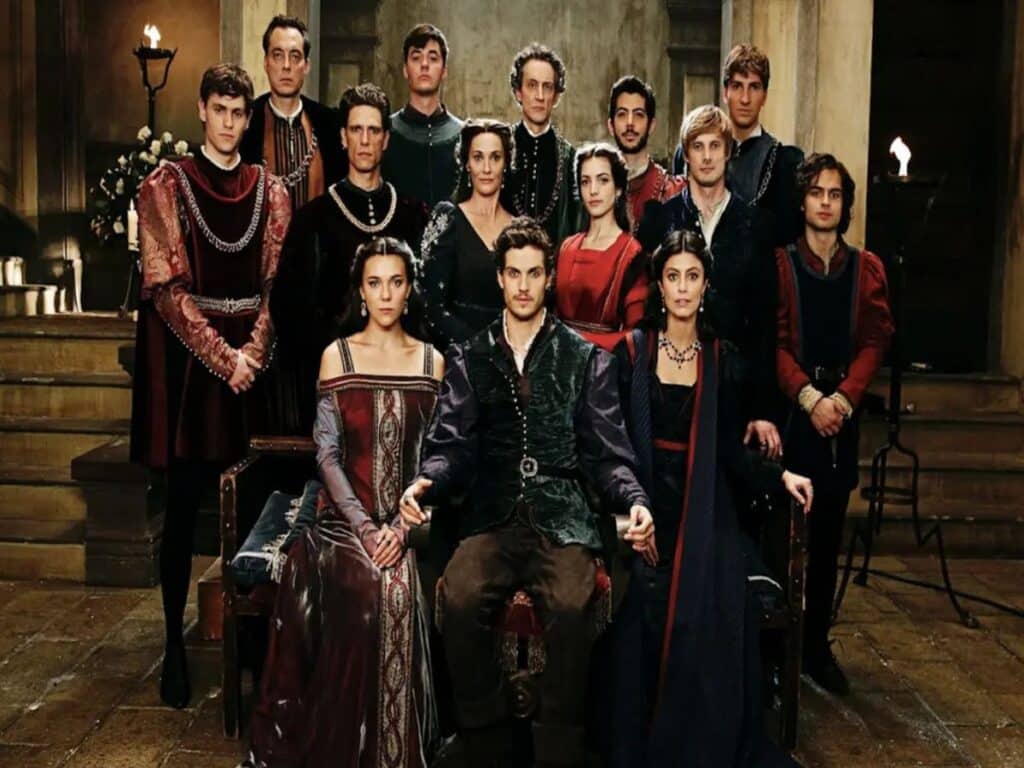 A richly dressed Renaissance-era family poses formally inside a palace hall, reflecting political intrigue and aristocracy in a medieval-themed TV series.
