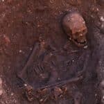 Skeletal remains in a shallow grave, partially uncovered in an archaeological trench. These bones were later confirmed to belong to Richard III, the Last Plantagenet King.