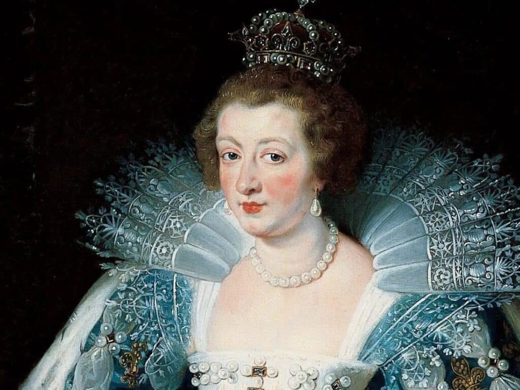 Portrait of Anne of Austria wearing a jeweled crown and pearl necklace, dressed in an ornate blue gown with elaborate lace ruff collar.