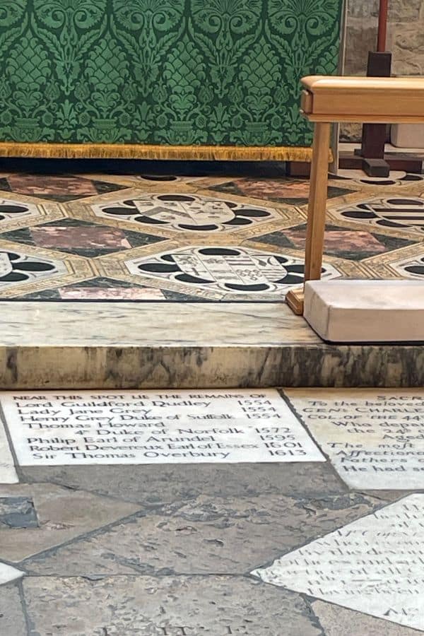 Stone floor memorial plaque inside a chapel listing the names and death years of several historic figures, including Lady Jane Grey and Lord Guildford Dudley. This plaque lies within the Tower of London’s chapel, marking the resting place of notable executed prisoners.