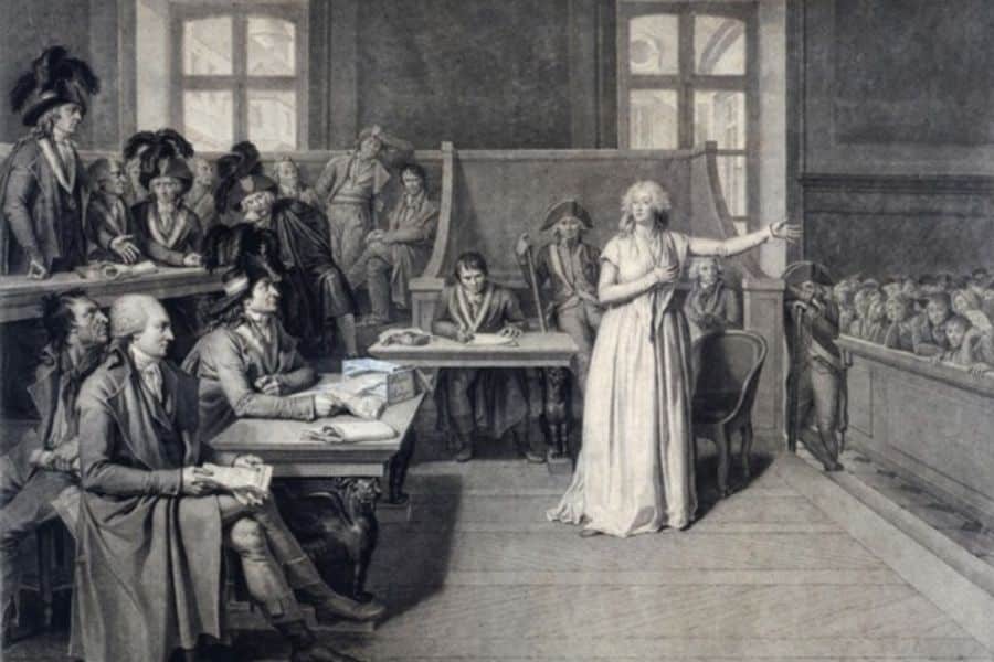 A courtroom scene showing Marie Antoinette on trial before Revolutionary judges, raising her arm in defiance or appeal. This trial was a pivotal moment in the last days of Marie Antoinette.