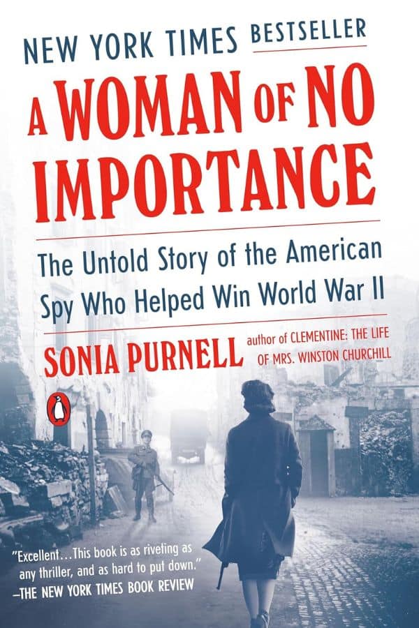 Book cover of A Woman of No Importance by Sonia Purnell, featuring a woman walking down a war-torn street with bold text highlighting the story of Virginia Hall, an American spy who helped win World War II.
