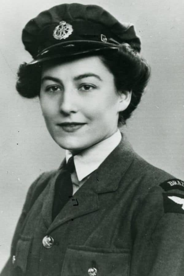 WWII-era portrait of a smiling woman in an Air Force uniform marked with “BRAZIL” on the sleeve, representing international agents coordinated by Vera Atkins.