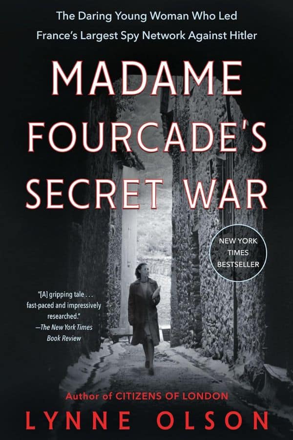 Cover of the book Madame Fourcade’s Secret War by Lynne Olson, featuring Marie-Madeleine Fourcade walking through a stone alley, highlighting her role as a wartime intelligence leader.