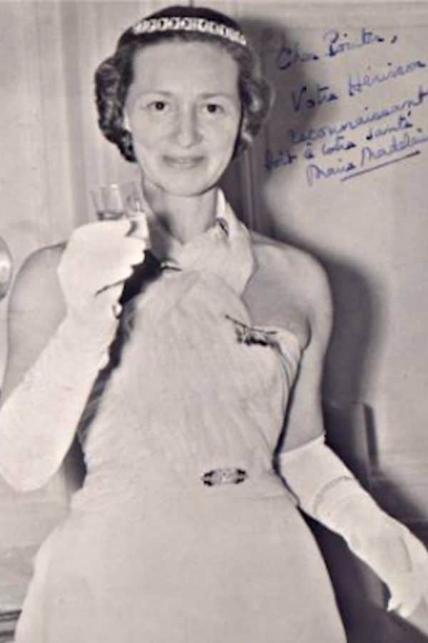 Marie-Madeleine Fourcade dressed in a formal gown and gloves, raising a glass in a celebratory moment, reflecting her post-war recognition and legacy.