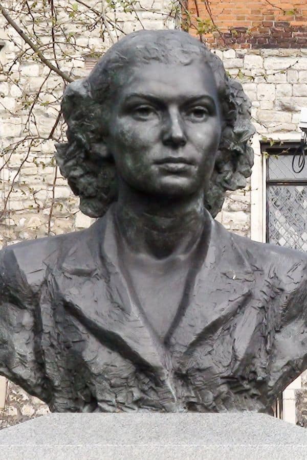 A bronze bust of Violette Szabo stands against a stone wall, commemorating her bravery and sacrifice. This statue honors Violette Szabo as one of Britain's most heroic WWII agents.