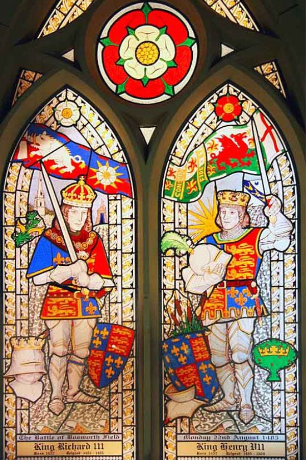 Stained glass window depicting King Richard III and King Henry VII with royal heraldry, banners, and the white and red roses associated with the Battle of Bosworth. The artwork commemorates the rival leaders whose conflict reshaped the English monarchy.
