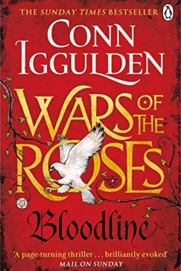 Red book cover for "Wars of the Roses. Bloodline" by Conn Iggulden with a white falcon flying across gold lettering and thorny branches. Cover text also reads "The Sunday Times Bestseller" and "A page turning thriller. Brilliantly evoked. Mail on Sunday."