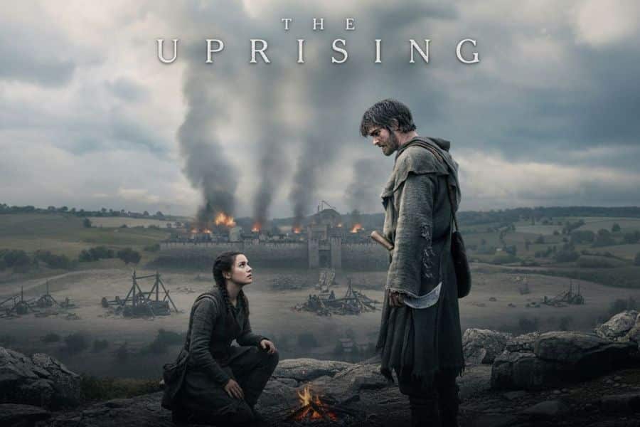 Promotional artwork for The Uprising showing a hooded man holding a curved blade standing over a kneeling woman as a fortified castle burns in the background beneath dark, stormy skies. The dramatic medieval scene reflects the conflict and tension at the heart of The Uprising, with the title "THE UPRISING" displayed across the top.