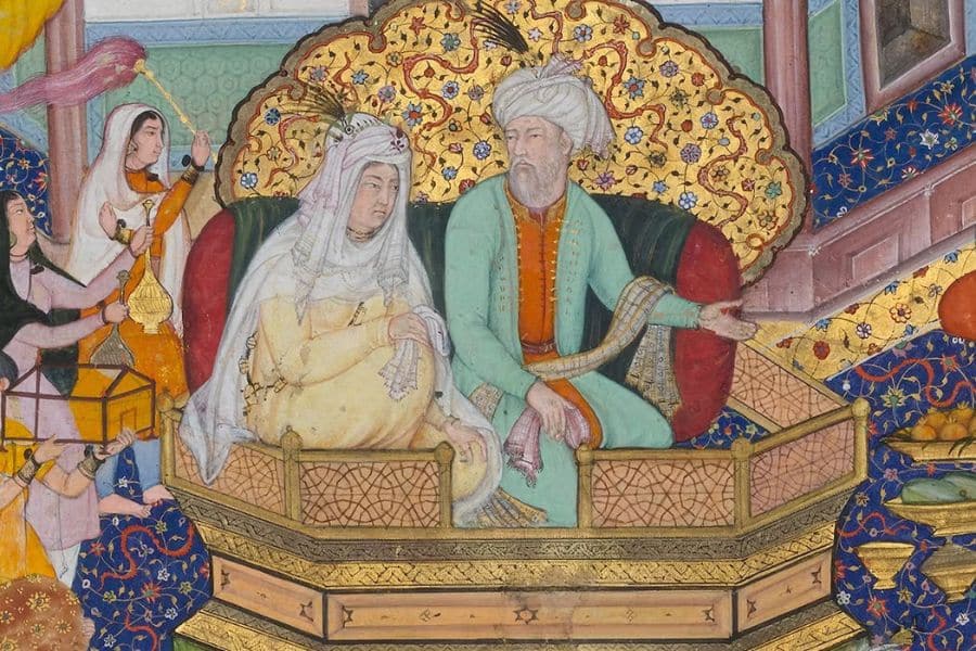 A colorful historical miniature depicts an older man and woman seated together on an ornate platform surrounded by attendants. The figures wear richly decorated robes and head coverings against intricate gold and floral patterns.