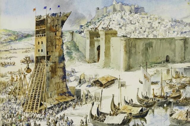 A fortified coastal city under attack with a tall wooden siege tower pressed against the walls and crowds of soldiers gathered below. Ships fill the harbor beside the defenses and a castle rises above the hillside city in this depiction of medieval sieges.