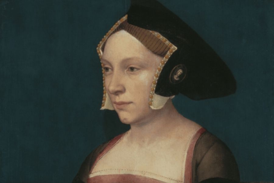Painted Tudor era portrait of a woman wearing a dark angular headdress with gold trim and a square necked gown. Her formal clothing reflects the courtly fashion associated with Ladies-in-Waiting.